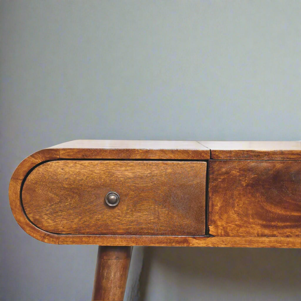 Close view of left side of rounded dressing table, with chestnut finish, showcasing smooth rounded edge and closed drawer with pull handle.