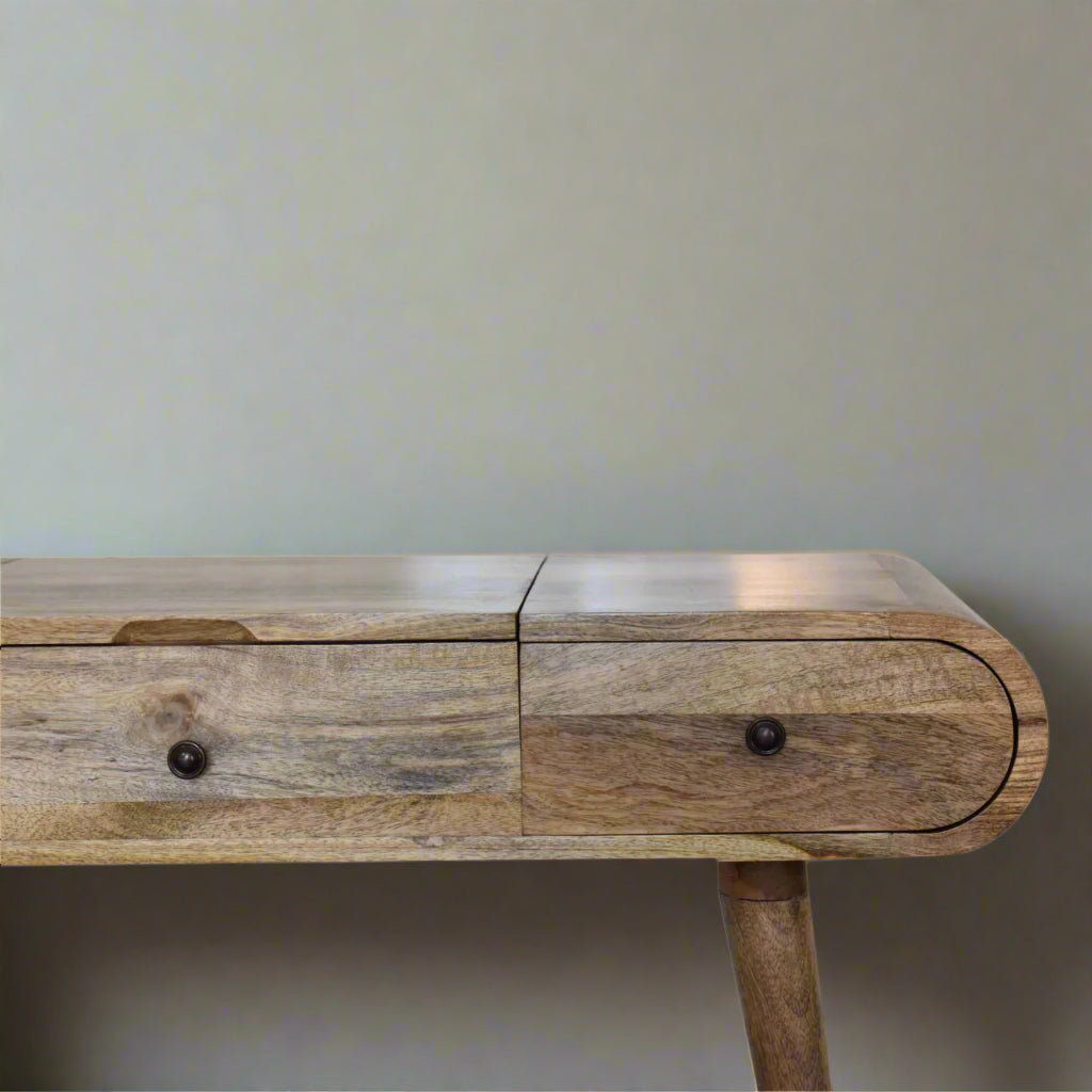 Close view of right side of rounded dressing table, with oak-ish finish, showcasing smooth rounded edge and closed drawers.