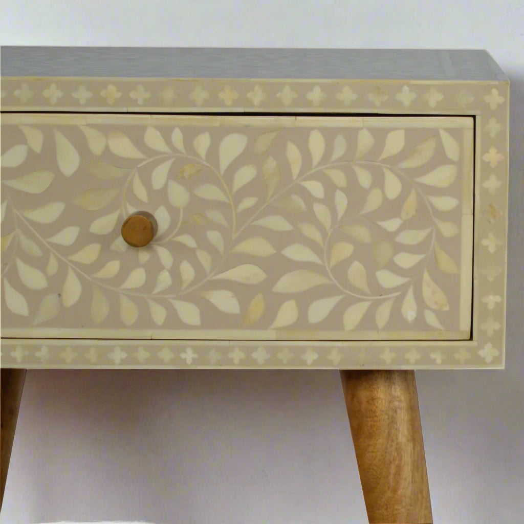 Closer shot of the front side of the Floral Bone Inlay 1 Drawer Bedside Table in grey, highlighting the intricate floral bone inlay pattern, knob, and section of the legs.