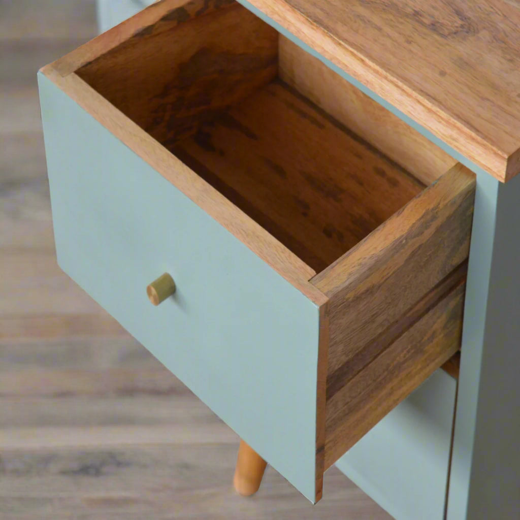 Top-down view of the green hand-painted bedside table with the top drawer pulled open, revealing the interior storage and the wooden top surface.