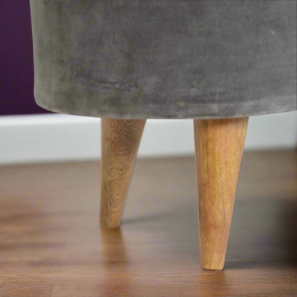 Closeup of the Nordic style solid wood legs of the Grey Velvet Storage Footstool, showcasing their oak-ish finish.