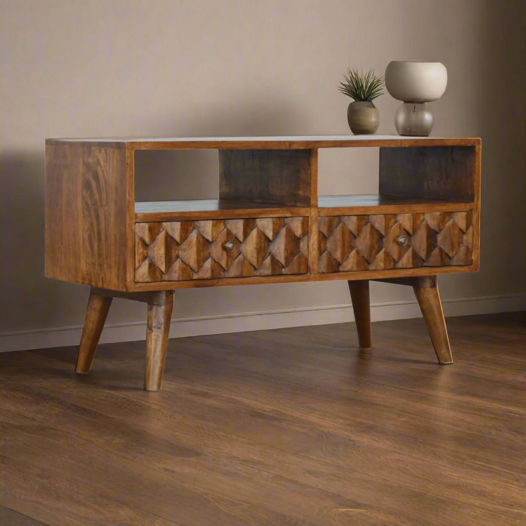 Angled view of mango wood TV stand with pineapple pattern drawer fronts and open shelf storage