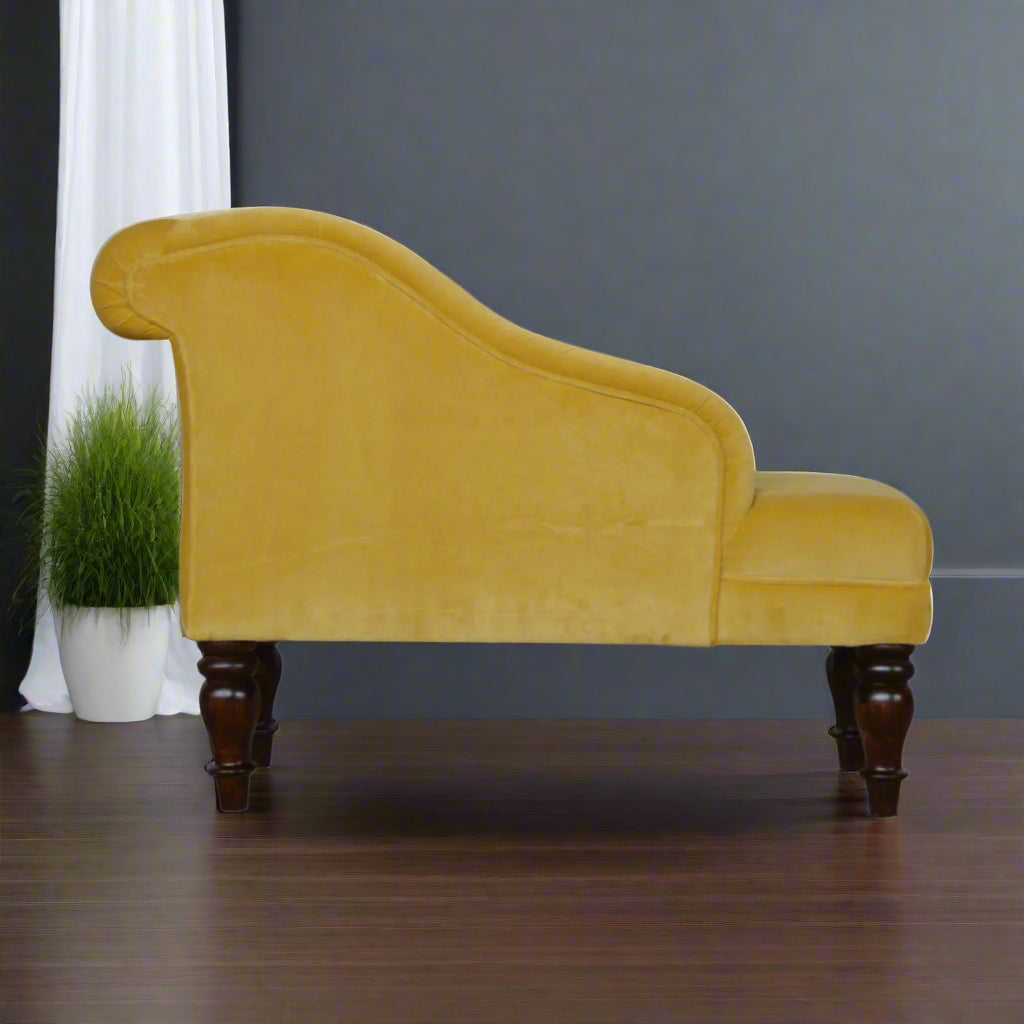 Back view of the mustard velvet chaise, showing its rear construction and the turned legs.