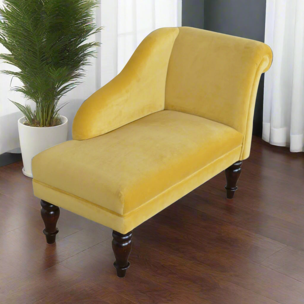 Elevated angled view of the mustard velvet chaise, showcasing its comfortable padded seat, with an inhouse plant in the background.