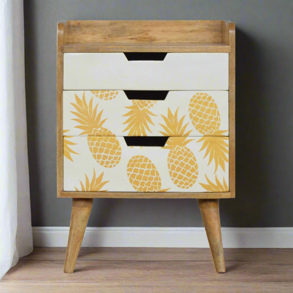 Pineapple Screen Print 3 Drawer Bedside Table in an oak-ish finish, positioned in a modern room setting, highlighting its functional storage and decorative appeal.
