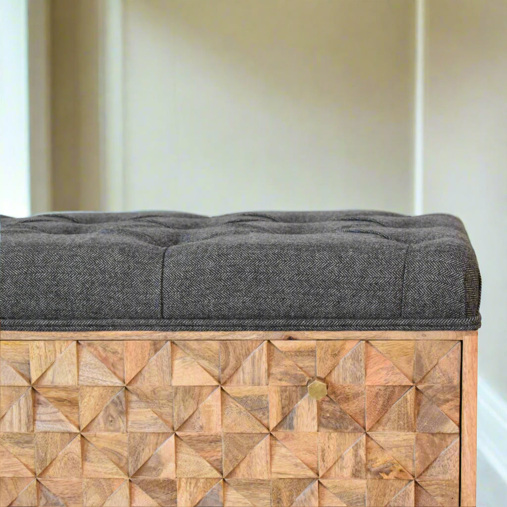 Close-up of hand-carved pineapple design on solid wood storage bench.