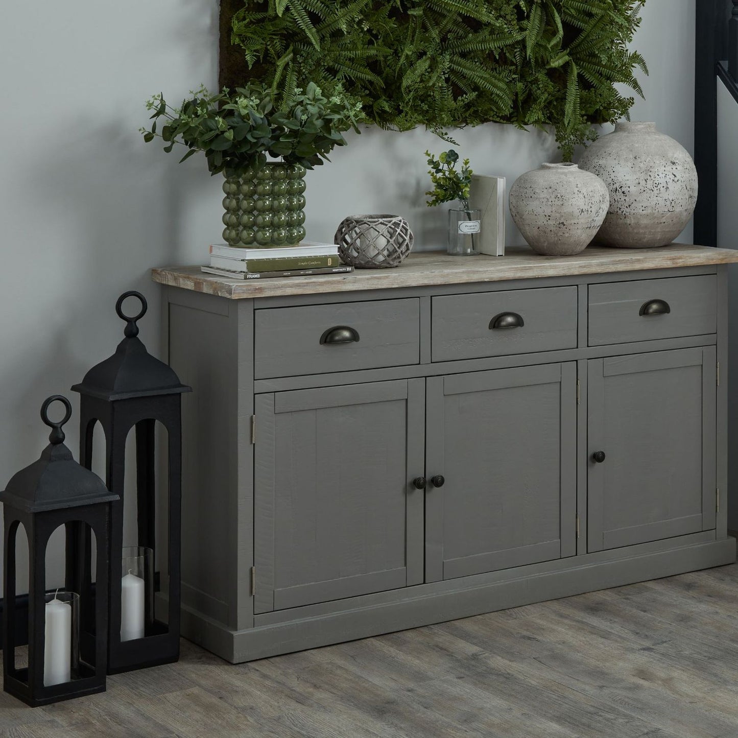 Angled shot of the lantern on a grey cupboard with floral décor and a white top.