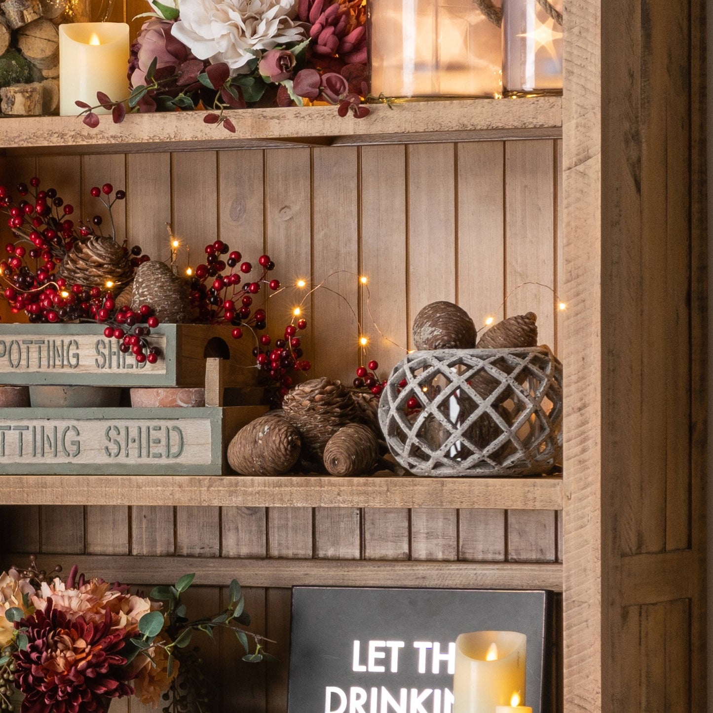Ceramic lantern displayed in a shelf compartment surrounded by other decor items.