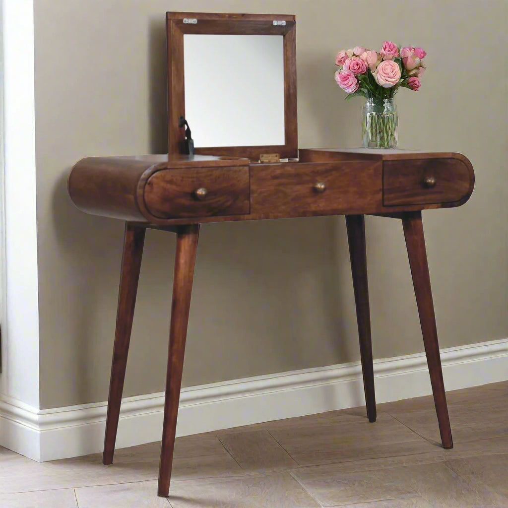 rounded dressing table with honey caramel finish, front angled view, showcasing the fold-up mirror open and vase and flowers on tabletop.