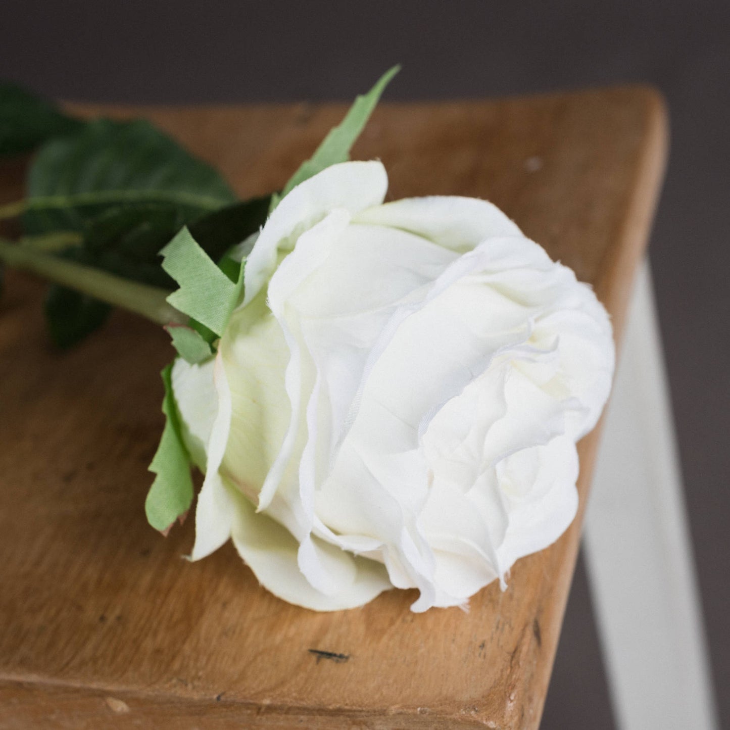 Zoomed-in overhead shot of a faux traditional white rose showing its crisp white petals.