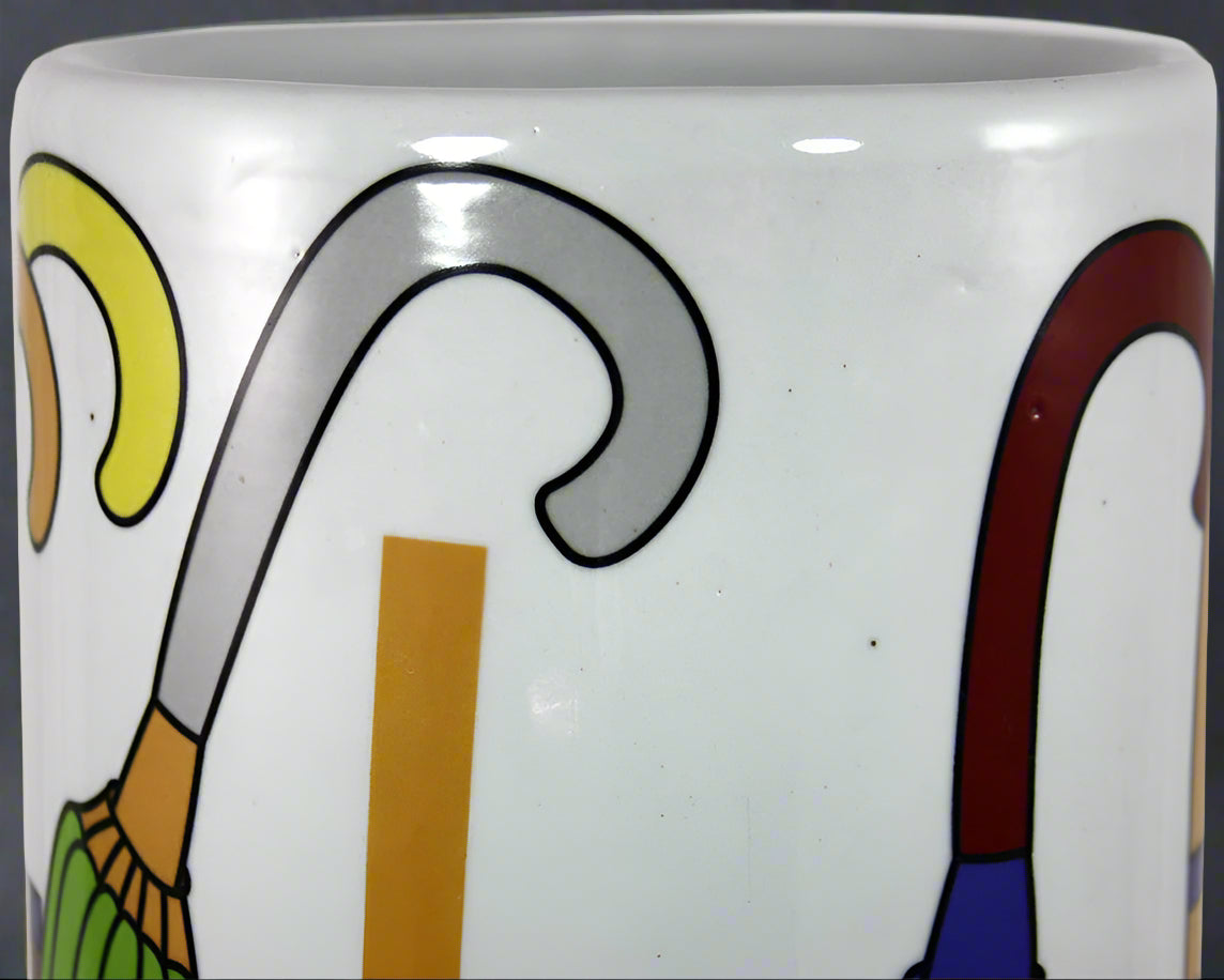 Close-up of the multi-coloured umbrella design on the glazed ceramic stick stand, showing the vintage-inspired appearance and distressed finish details.