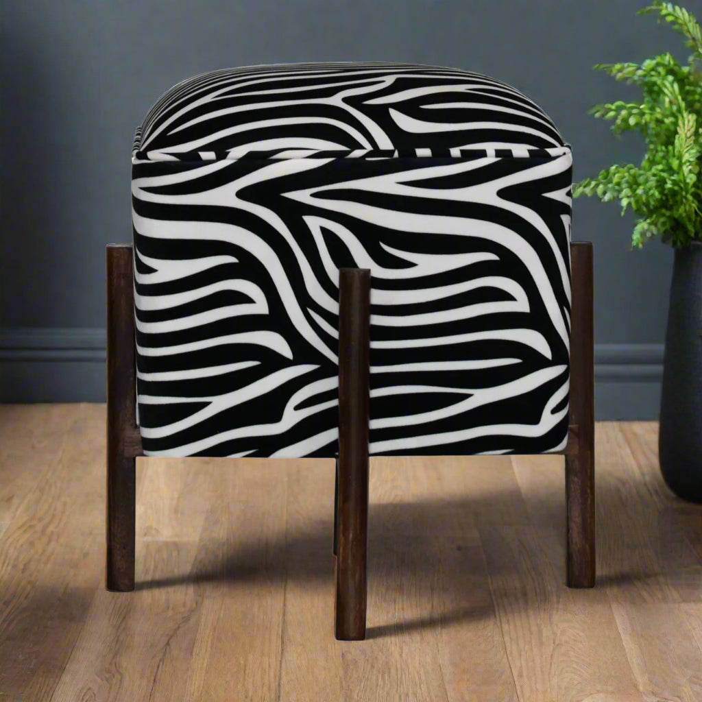 Front view of zebra print footstool with curved edges and dark walnut wood legs
