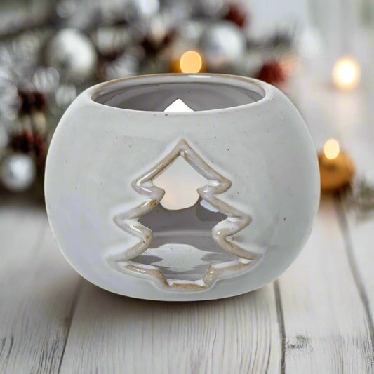 White round ceramic tealight holder with Fir tree shape cutout on both sides, which casts enchanting shadows when tealight lit.
