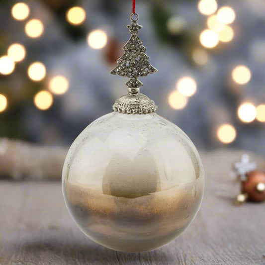 Large Decorative Christmas Glass Bauble with coffee ombre colouring and intricate bejewelled tree-shaped top. Festive scene.