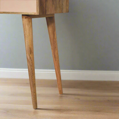 Lower view of the cut out hand painted mini dressing table pink paint oakish-finish, displaying close up of right nordic style legs
