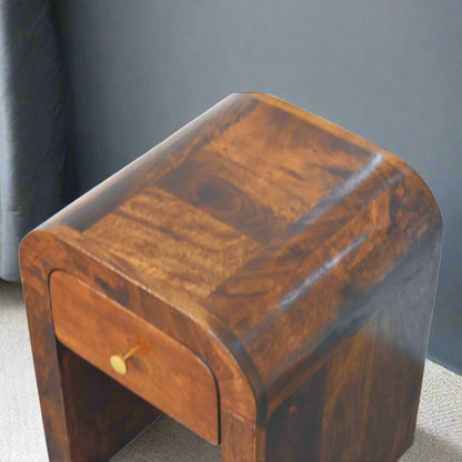 Angled view of the Mini Darcy Chestnut Nightstand highlighting its smooth, curved edges and warm chestnut mango wood grain.