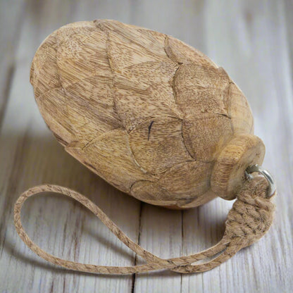 Close up view of wooden pine cone hanging decoration, showcasing the beautiful cone carvings