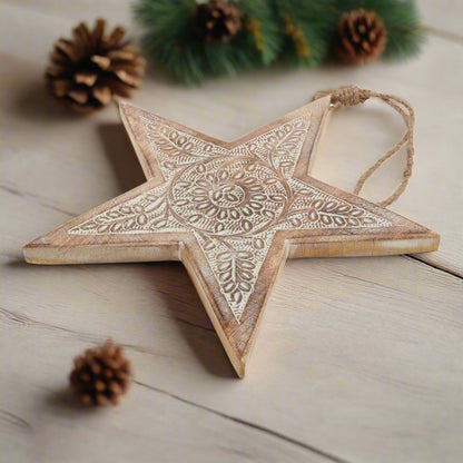 Wooden star hanging decoration placed down on table, showcasing close up of   intricately cut pattern and hanging twine, buy at Purple Flamingo UK