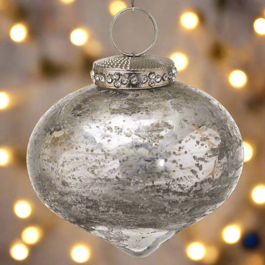 Decorative antique silver tear-shaped Christmas Bauble adorned with a crystal encrusted cap, hanging in a festive fairy light setting.