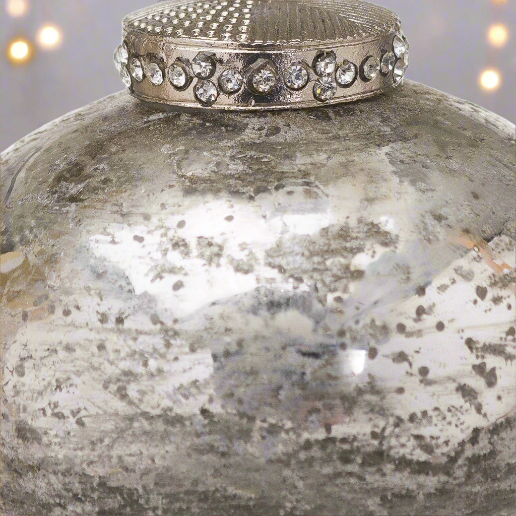 Close up view of a decorative antique silver Christmas Bauble adorned with a crystal encrusted cap,