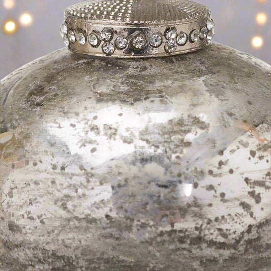 Close up view of a decorative antique silver Christmas Bauble adorned with a crystal encrusted cap,