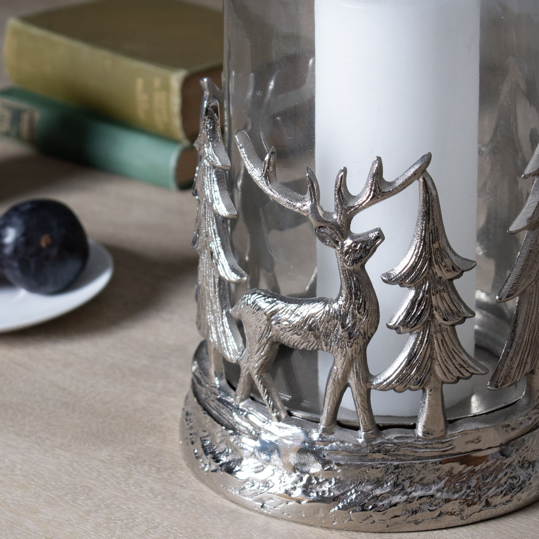 close up bottom view of decorative hurricane lantern displaying beautiful metal cut-out design of deer and nordic trees. Purple Flamingo UK.