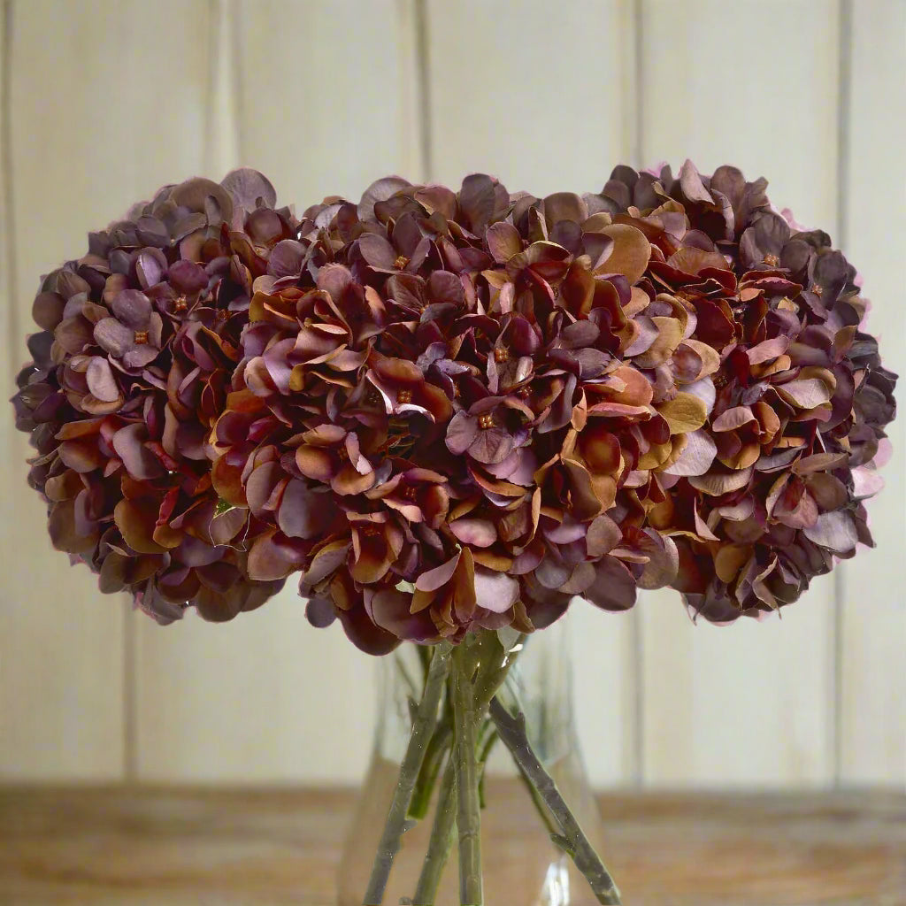 Bunch of Autumn Coffee Hydrangea stems in a clear glass vase – warm-toned artificial florals for autumnal home styling, from Purple Flamingo UK.