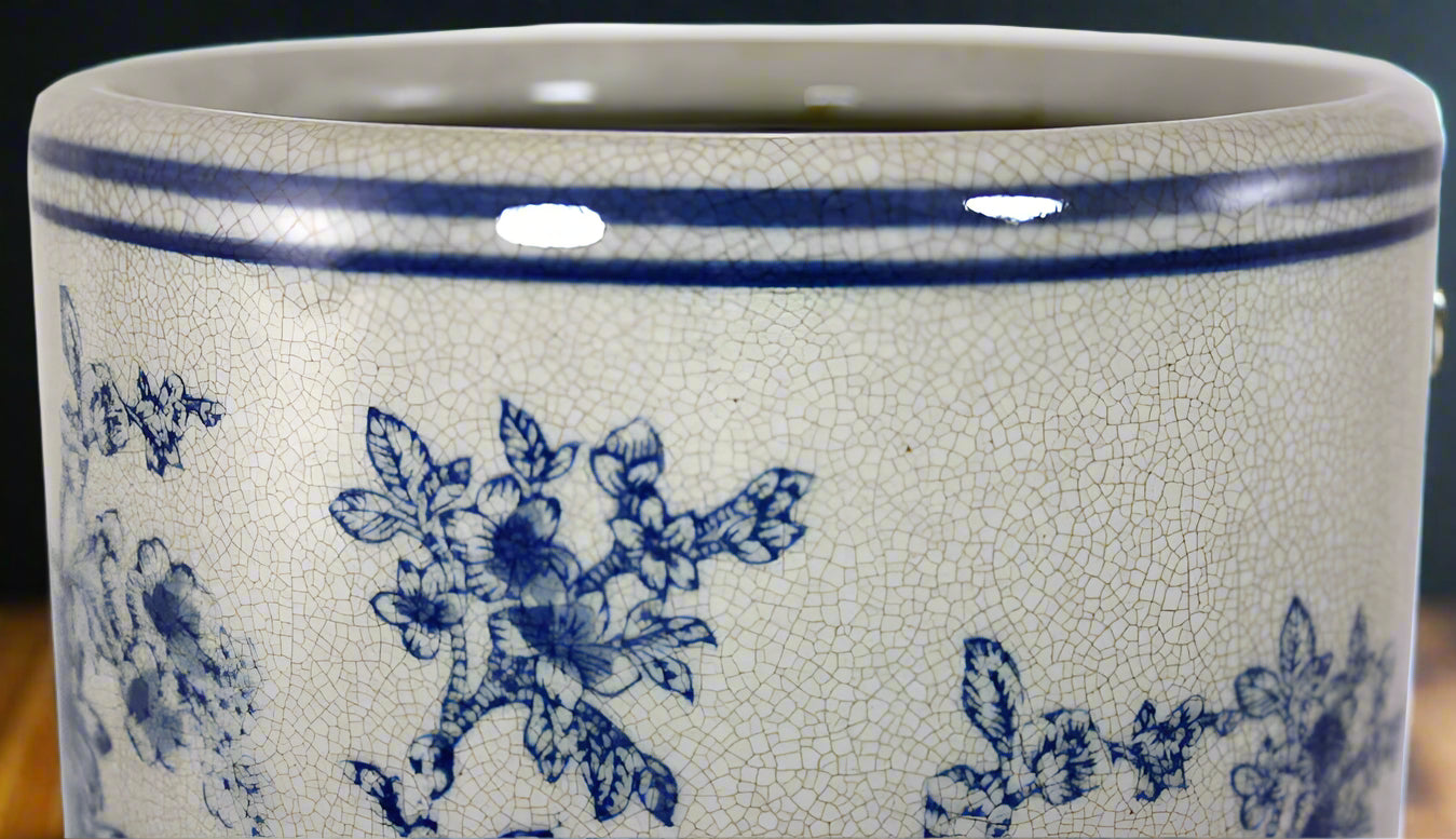Close up detail of blue and white magnolia pattern on vintage ceramic umbrella stand showing traditional floral design