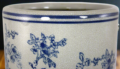 Close up detail of blue and white magnolia pattern on vintage ceramic umbrella stand showing traditional floral design
