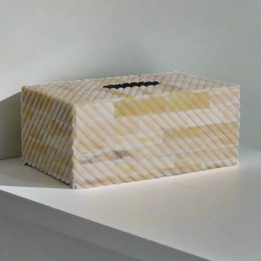 Angled image of tissue holder on white tabletop showing intricate patterning and artisanal elegance.