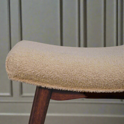 Close view of the right edge of the Boucle Cream Curve Stool, highlighting the textured cream boucle fabric.