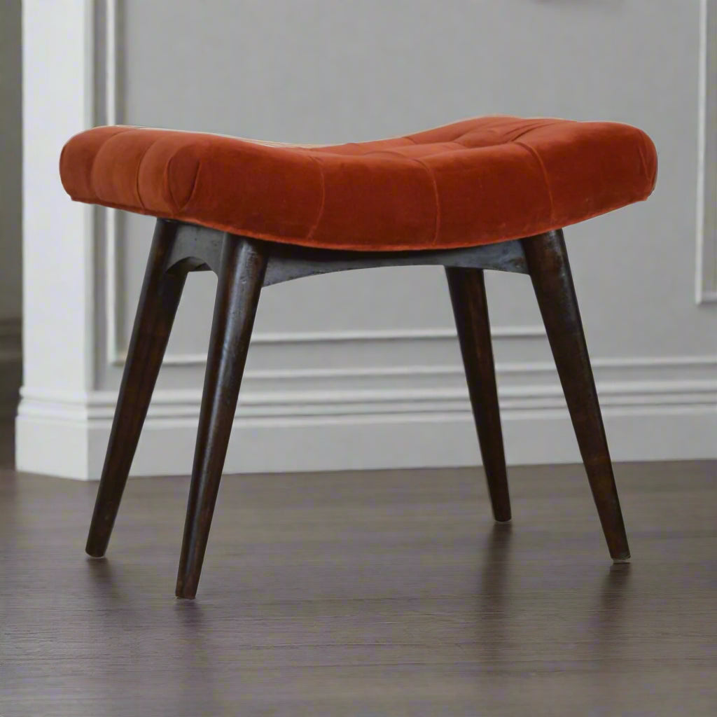 Angled view of brick velvet curve stool with four Nordic legs