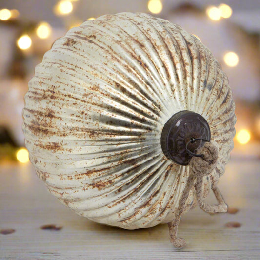 Close-up of a burnished glass fluted bauble, showing the intricate ribbed pattern and the rustic bauble cap and hanging twine.