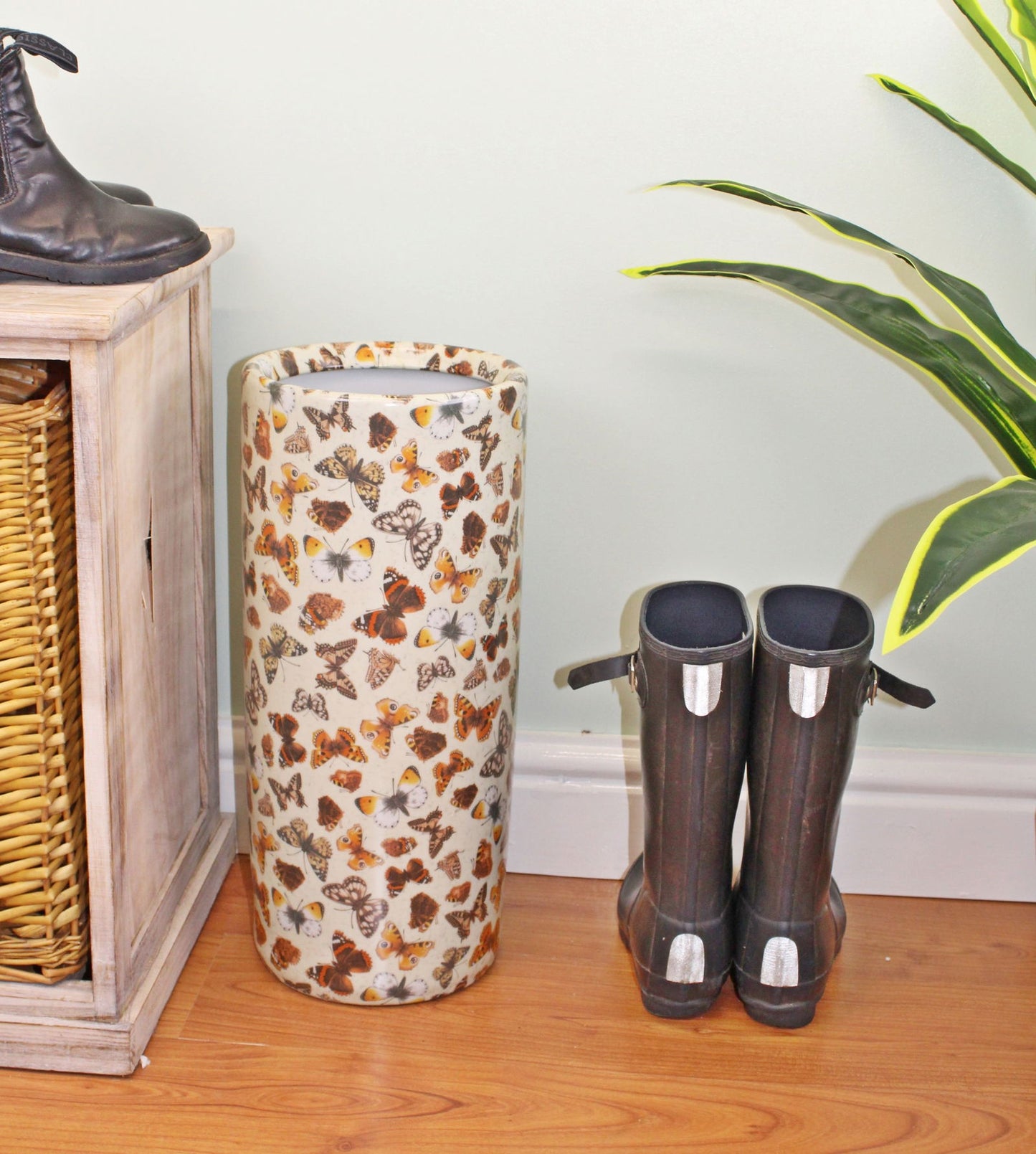 Butterfly ceramic umbrella and stick stand styled in a hallway next to a pair of black boots on wooden floor – Purple Flamingo UK