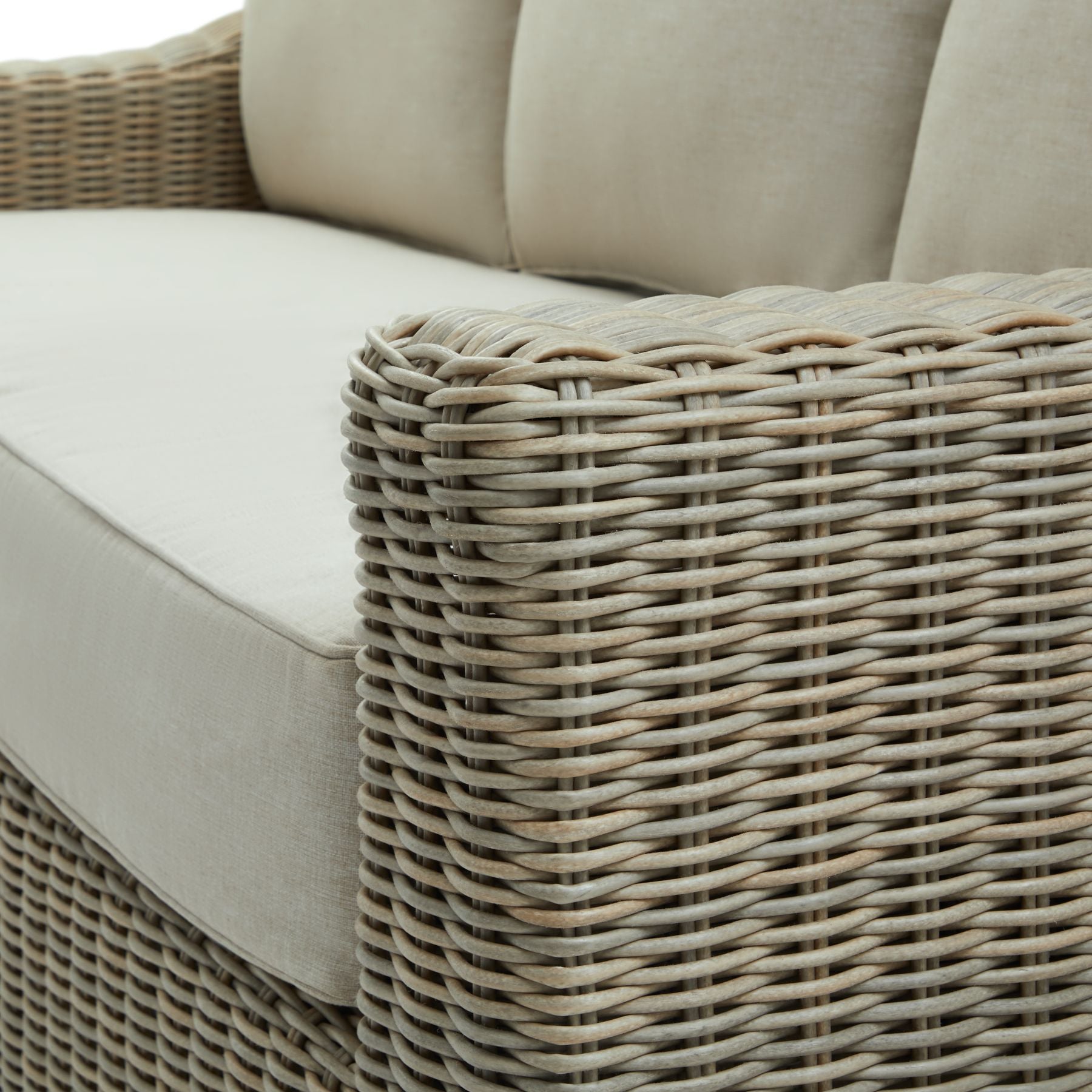 Angled close-up of the Capri Three-Seater Sofa, highlighting the intricate HDPE wicker weave and plush Olefin cushions.