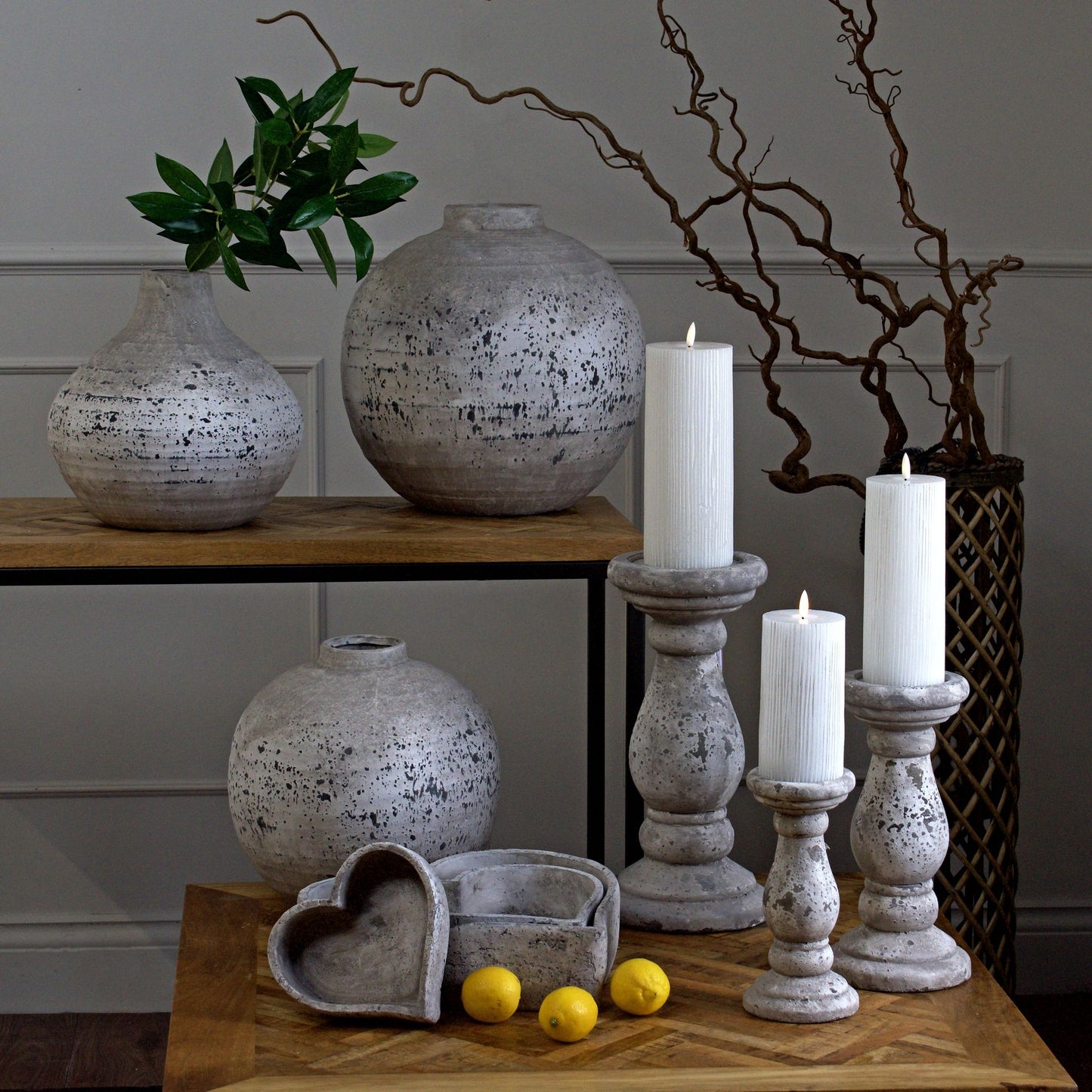 Heart-shaped stone dishes styled with other home accessories like a stone pear and potted orchid, creating a cozy tabletop arrangement.
