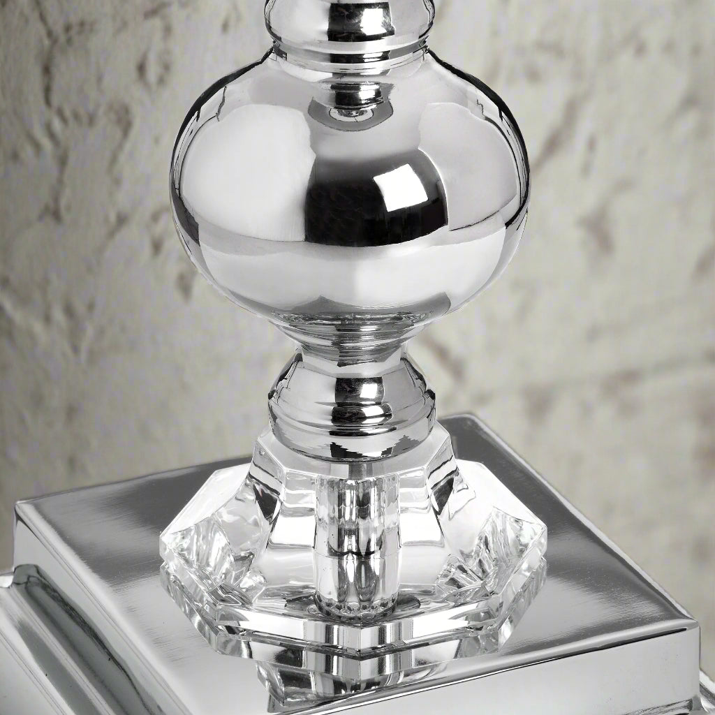 Close-up of the Milan lamp's chrome base, showcasing intricate hand-cut glass design that reflects light for an elegant finish.