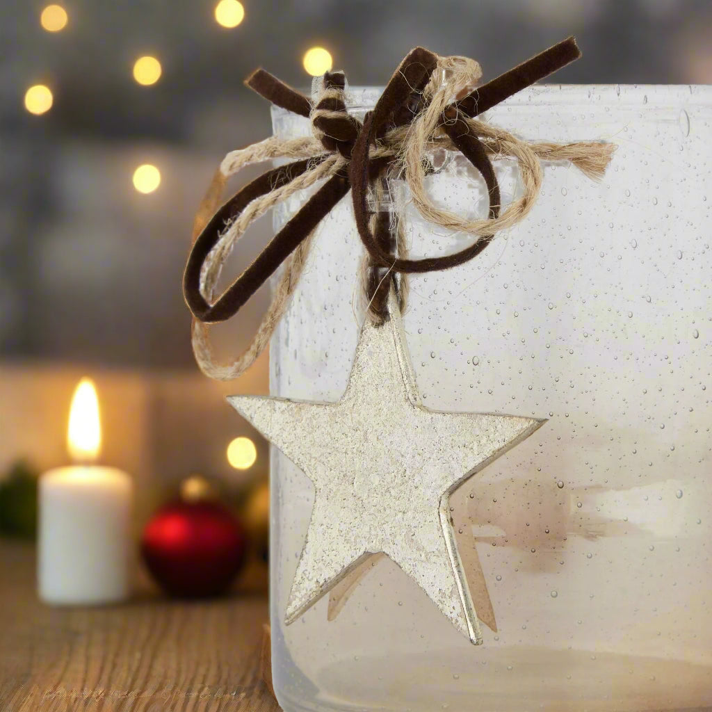 close up view of the decorative star and twine and velvet ribbon attached to the coffee ombre tone candle holder. Shop at Purple Flamingo UK.