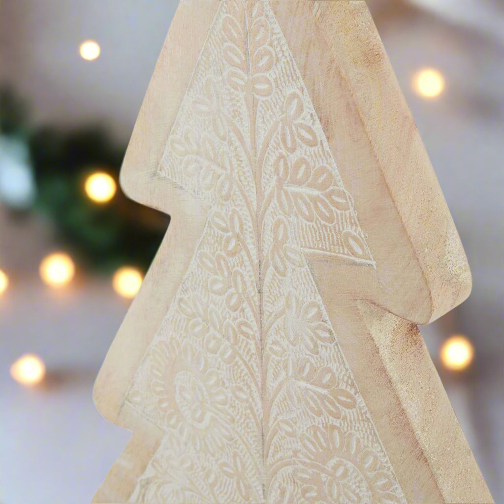 Close up of top half of a Wooden Christmas tree ornament showcasing the intricate patterns detail.