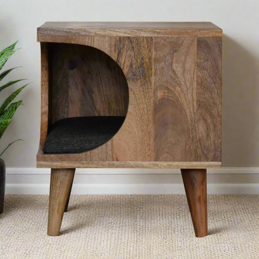 Corner cut-out pet bed made from solid mango wood with an oak-like finish, showing its Scandinavian-inspired design and curved entrance.