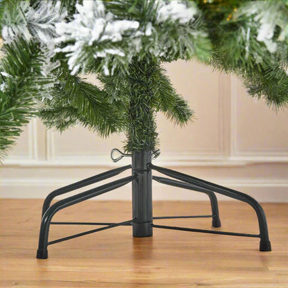 Close-up of the sturdy black metal stand supporting the extra large artificial snowy spruce Christmas tree, ensuring stability.