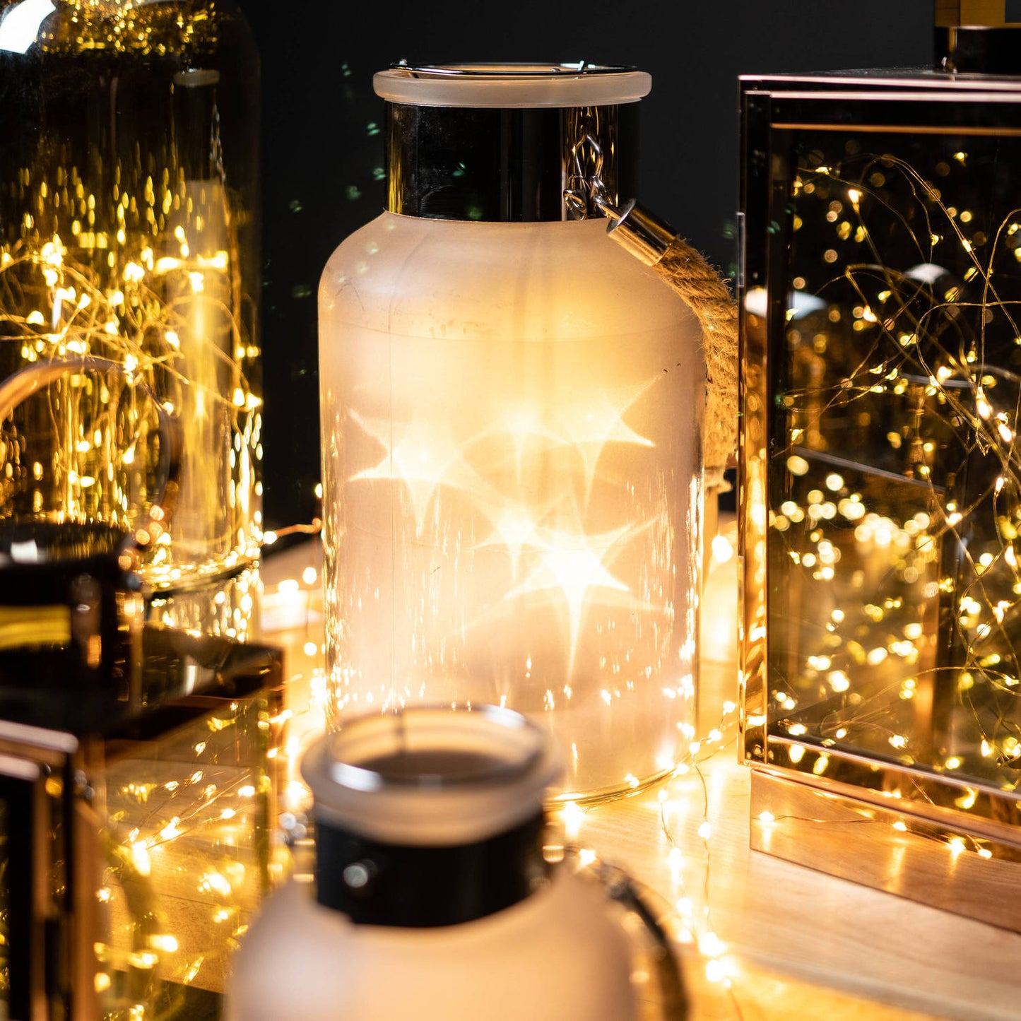 Front view of the frosted grey glass lantern with glowing LED and festive lighting.

