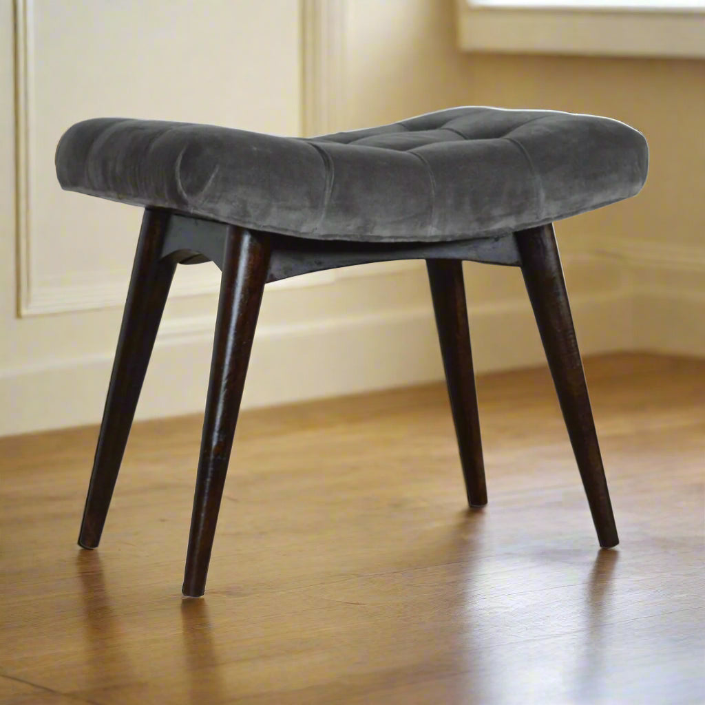 Front angled view of the grey velvet curve stool, showcasing its design and all four Nordic style legs.