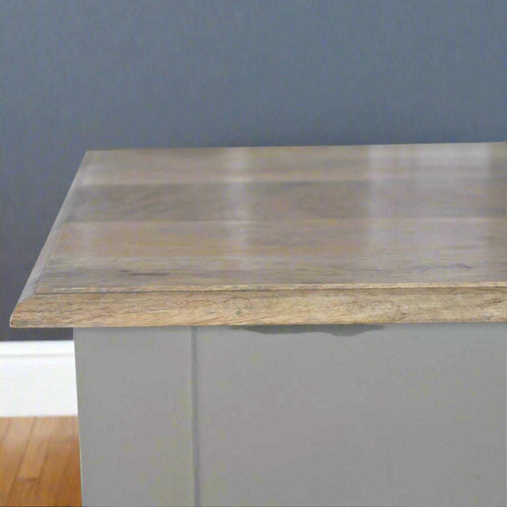 Elevated view of the Hand Painted Desk, showing the wood pattern on its top and the beginning of the French grey hand-painted base.