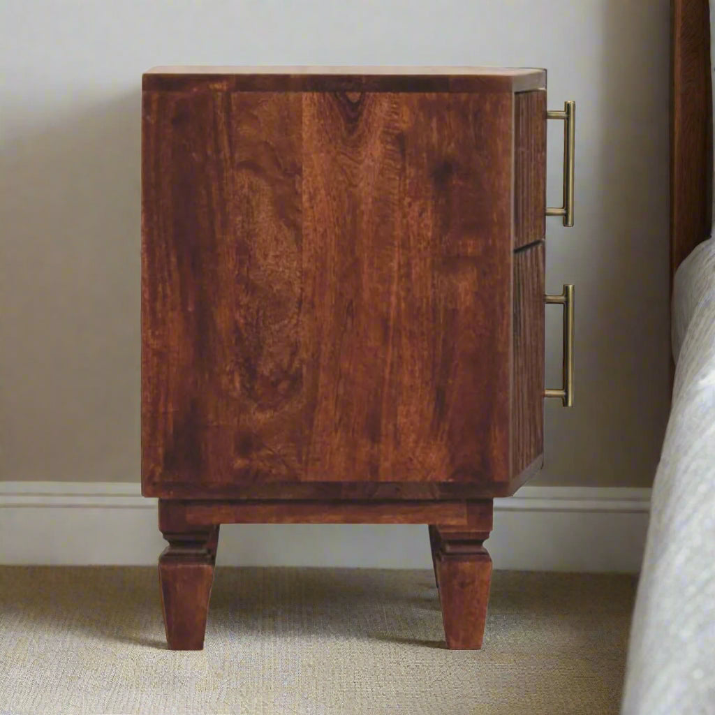 Side view of the harper bedside table, with amber oakt finish, displaying the carved detail of the legs.
