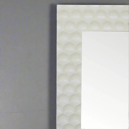 Close-up of the top right section of the Honeycomb Mirror's hand-carved, white honeycomb pattern frame.