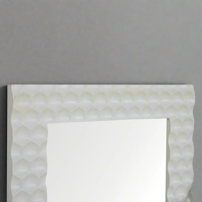 Upper half view of the Honeycomb Mirror, showing the reflection and the detailed hand-carved white honeycomb frame against a grey wall.