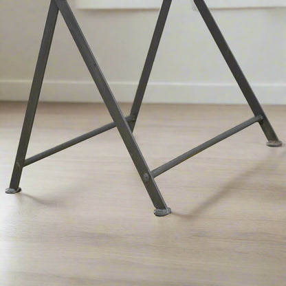 Zoomed-in view of the cross iron base, showing sturdy construction and foldable practicality.