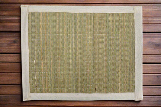Overhead flatlay of the four woven jute place mats laid side by side, showing their rectangular shape and clean border design on a wooden surface.