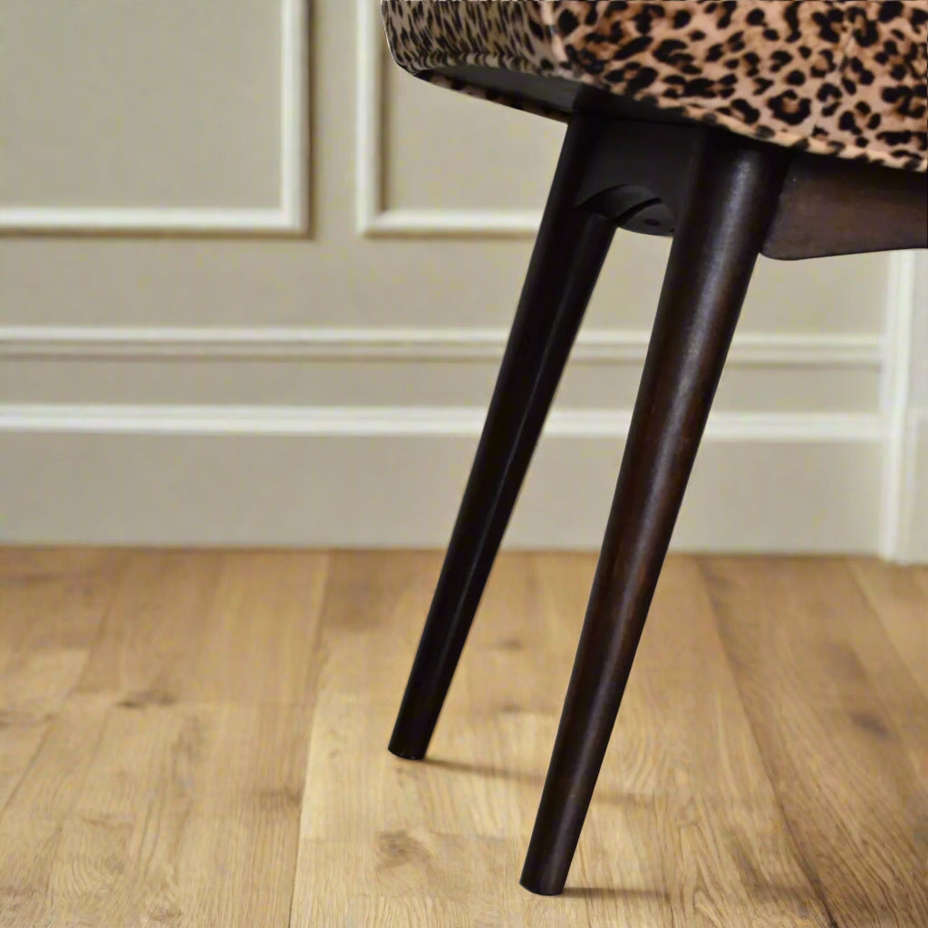 Close-up view of the Leopard Print Curve Stool's Nordic style legs, emphasizing their design and walnut finish.